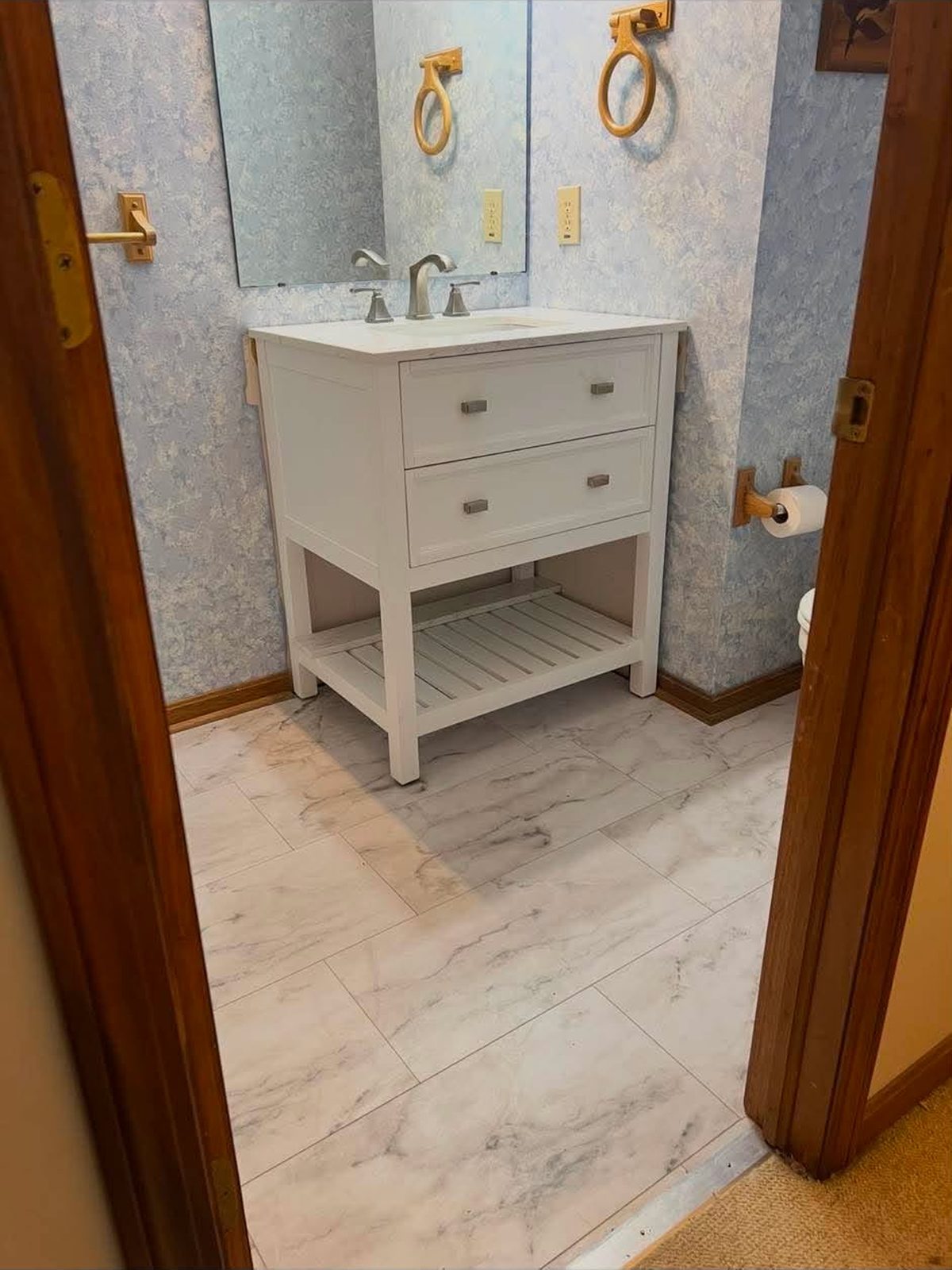 White powder-room vanity with a marble-look tile floor