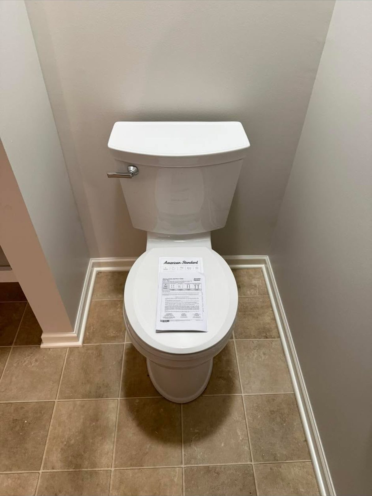 New white toilet installed on a tile floor